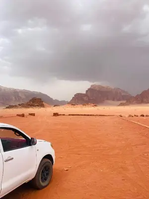 a white car parked in the desert at desert Hawk in Wadi Rum