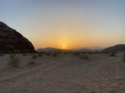 a sunset in the desert with a dirt road at Salem Wadi Rum Road in Wadi Rum