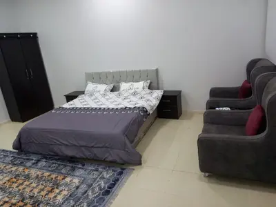 a bedroom with a bed and a couch and a chair at Samira House in Amman
