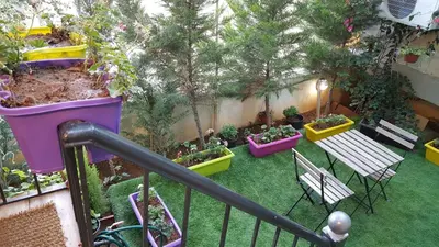 a balcony with a garden with benches and potted plants at Two Bedroom Shmeisani Apartment in Amman