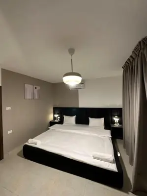 a bedroom with a large bed with white sheets at Stylish Luxe Apartment F/R 0001 in Amman
