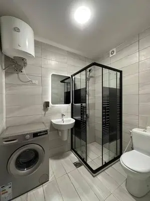 a bathroom with a washing machine and a sink at Stylish Luxe Apartment F/R 0002 in Amman