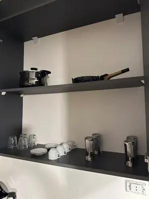 a kitchen shelf with dishes and utensils on it at Stylish Luxe Apartment F/R 0002 in Amman