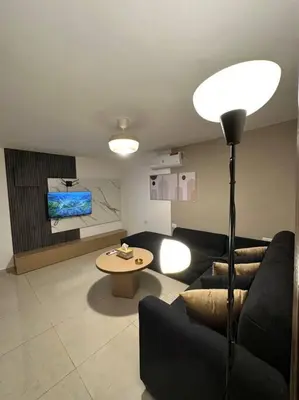 a living room with a couch and a table at Stylish Luxe Apartment F/R 0004 in Amman