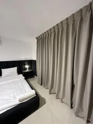 a bedroom with a bed and curtains in it at Stylish Luxe Apartment F/R 0004 in Amman