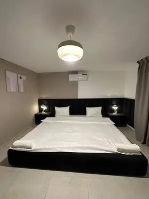a bedroom with a large white bed with a light at Stylish Luxe Apartment F/R 0004 in Amman