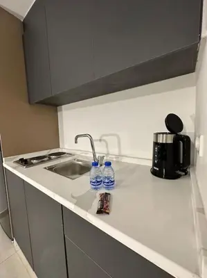 a kitchen counter with a sink and two water bottles at Stylish Luxe Apartment F/R 0004 in Amman