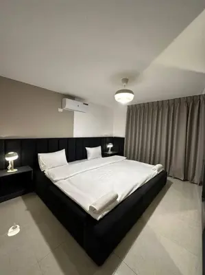 a bedroom with a large bed with white sheets at Stylish Luxe Apartment F/R 0005 in Amman