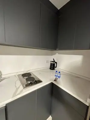 a kitchen counter with a stove and bottles on it at Stylish Luxe Apartment F/R 0005 in Amman