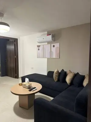 a living room with a blue couch and a table at Stylish Luxe Apartment F/R 0005 in Amman