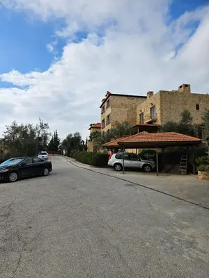 two cars parked in a parking lot next to a building at Horizon Loft in Bilāl