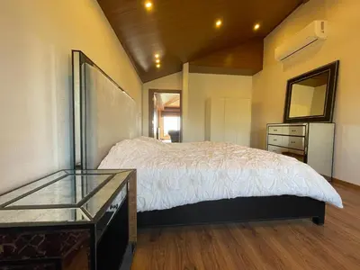 a bedroom with a bed and a dresser and a mirror at Horizon Loft in Bilāl