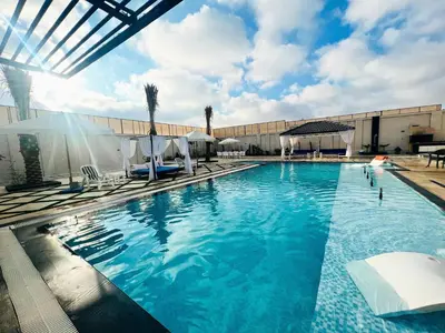 a swimming pool with chairs and a building at Tixos Farm in Irbid