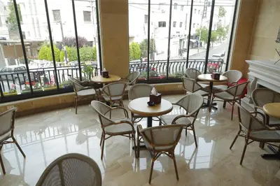 a restaurant with tables and chairs and a piano at Soho Midtown in Ash Shumaysānī