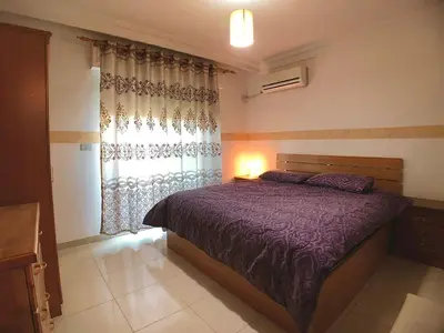 a bedroom with a purple bed and a window at Super modern comfortable apartment at the heart of historic Amman in Amman