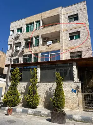 a brick building with trees in front of it at Super modern comfortable apartment at the heart of historic Amman in Amman