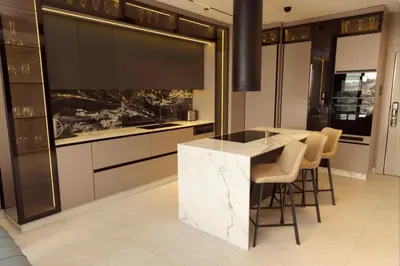 a kitchen with a marble counter and stools at Luxurious in Abdoun Tower at 11th Floor in Amman