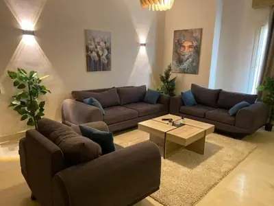 a living room with two couches and a coffee table at Holy land in Amman