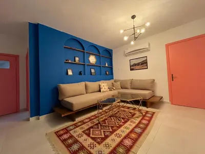 a living room with a couch and a blue wall at Lemon garden apartment in Aqaba