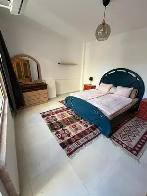 a bedroom with a bed with a blue frame and a rug at Lemon garden apartment in Aqaba
