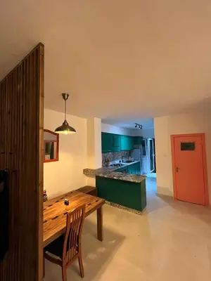 a kitchen with a wooden table and green cabinets at Lemon garden apartment in Aqaba
