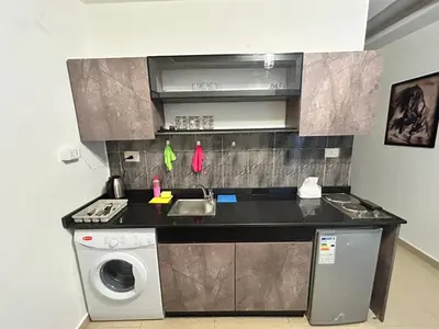 a kitchen with a sink and a washing machine at Luxury Hotel apartment in Amman