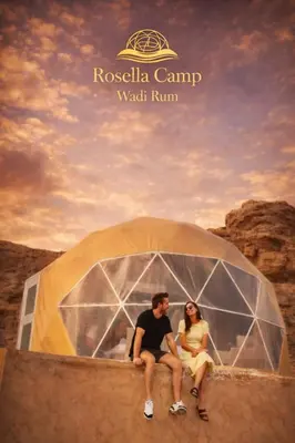 a man and a woman sitting in a tent at Rosella Camp Wadi Rum in Wadi Rum