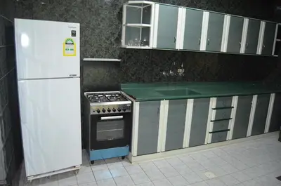 a kitchen with a white refrigerator and a stove at 2332 Guest House in Irbid