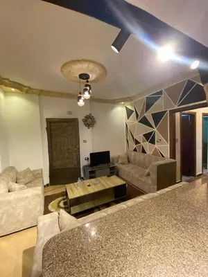 a living room with couches and a table at Nerman home in ‘Awjān ash Shamālī