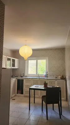 a kitchen with a table and a chandelier at Blackbird Sanctuary homestay & Art Cafe in Ajloun
