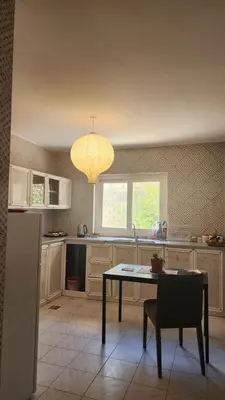 a kitchen with a table and a chandelier at Blackbird Sanctuary homestay & Art Cafe in Ajloun