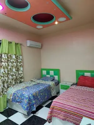 a bedroom with two beds and a ceiling with a fan at Araregj home in Amman