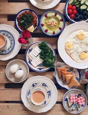 a wooden table with plates of breakfast food on it at Daria Luxury Camp in Wadi Rum