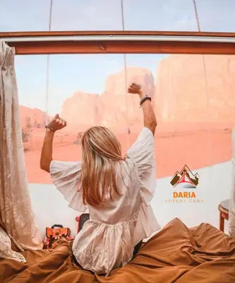 a woman looking out of a window at the desert at Daria Luxury Camp in Wadi Rum
