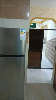 a kitchen with a stainless steel refrigerator in a room at شقة الياسمين العائلية الفاخرة in Amman