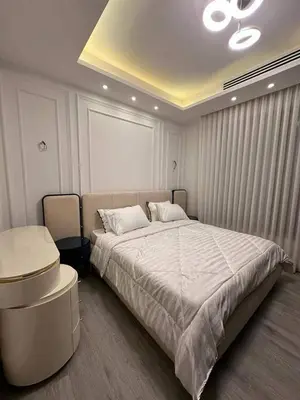 a bedroom with a large bed and a table at Maan 12 in Ma‘ān