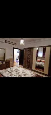 a large room with a bed and a chandelier at Maan 12 in Ma‘ān