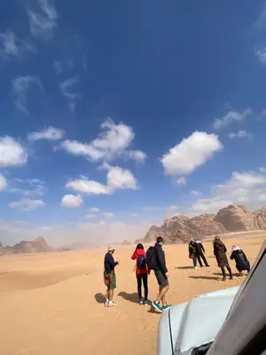 a group of people standing in the desert at Wadi Rum, sands of Mars in Wadi Rum