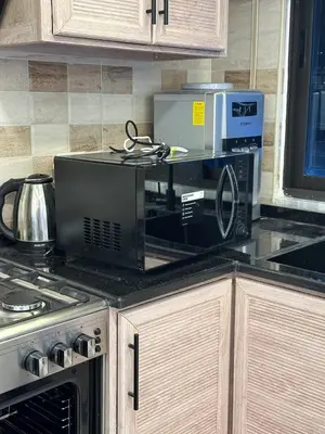 a kitchen counter with a microwave and a stove at 3 bed rooms apartment - 3 غرف نوم مفروشة دوار المشاغل عمان in Amman