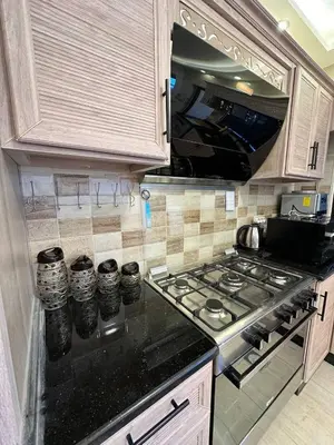 a kitchen with a stove and a stove top at 3 bed rooms apartment - 3 غرف نوم مفروشة دوار المشاغل عمان in Amman