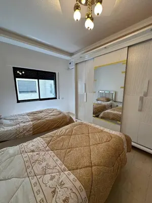 a bedroom with two beds and a large mirror at 3 bed rooms apartment - 3 غرف نوم مفروشة دوار المشاغل عمان in Amman