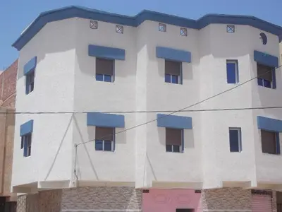 a large white building with blue windows on it at GOJORDAN INN in Irbid