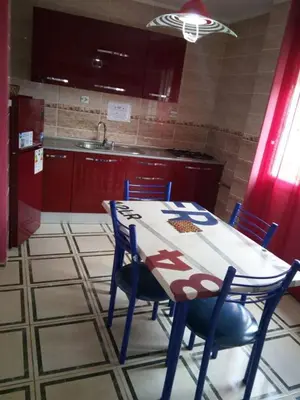 a kitchen with a table and chairs in a room at GOJORDAN INN in Irbid