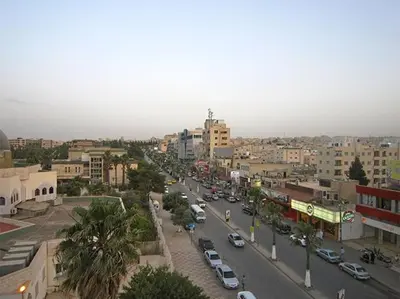 a city with cars parked on a street with buildings at GOJORDAN INN in Irbid