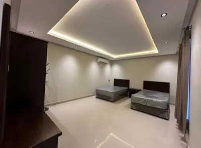 two beds in a large room with a ceiling at 89 inn in Amman