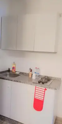 a kitchen counter with a sink and a red towel at Lovely Studio appartment in a central location in Amman
