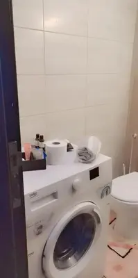 a washing machine in a bathroom with a toilet at Lovely Studio appartment in a central location in Amman