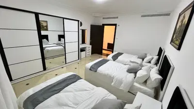 a room with three beds and a bedroom at شقة مفروشة اربع غرف نوم عبدون in Amman