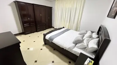 a bedroom with a bed with white sheets and pillows at شقة مفروشة اربع غرف نوم عبدون in Amman