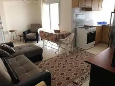 a living room with a couch and a table and a kitchen at lomez House in Amman